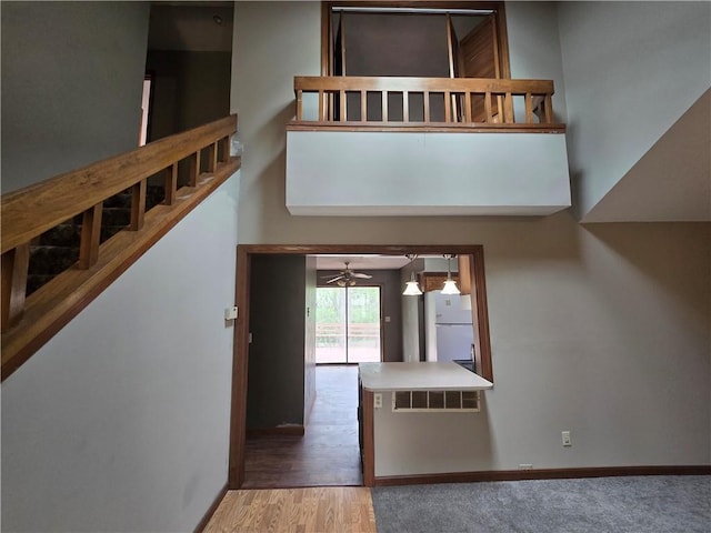 entrance foyer featuring wood finished floors, a ceiling fan, stairs, and baseboards