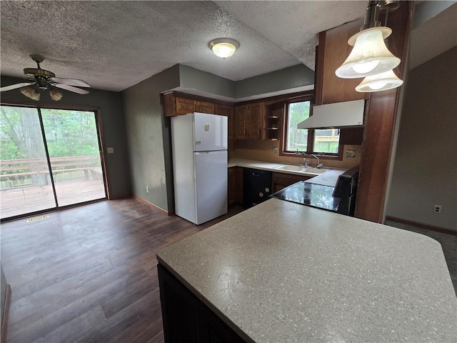 kitchen featuring baseboards, range, a textured ceiling, and freestanding refrigerator