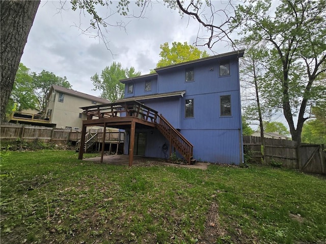 back of house featuring fence, stairway, a yard, and a wooden deck