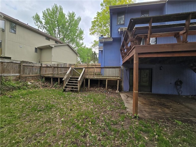 view of yard featuring a deck, fence, stairs, and a patio area
