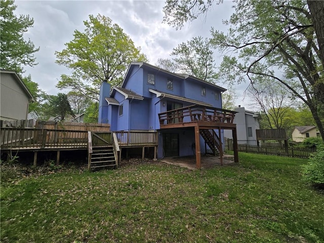 back of house featuring a deck, a lawn, stairs, and fence