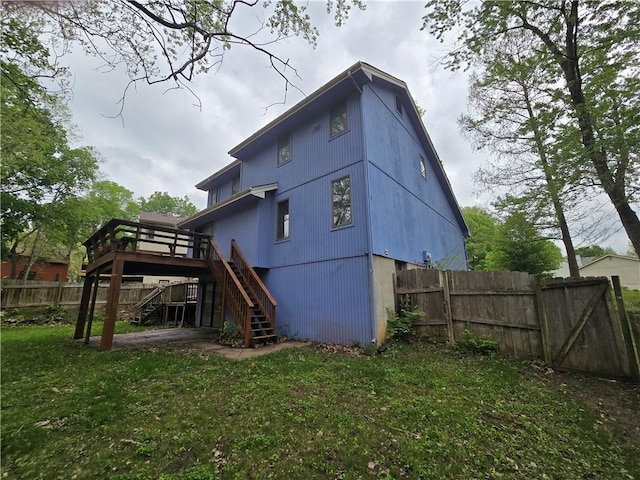 rear view of house featuring fence, stairway, a yard, and a wooden deck