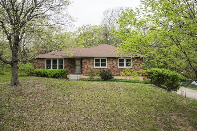 ranch-style home featuring brick siding and a front lawn