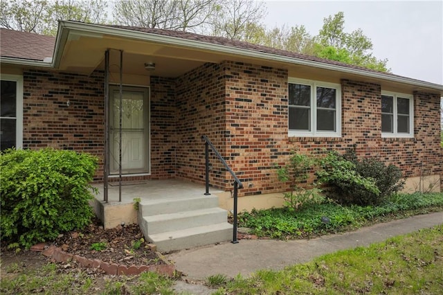 property entrance featuring brick siding