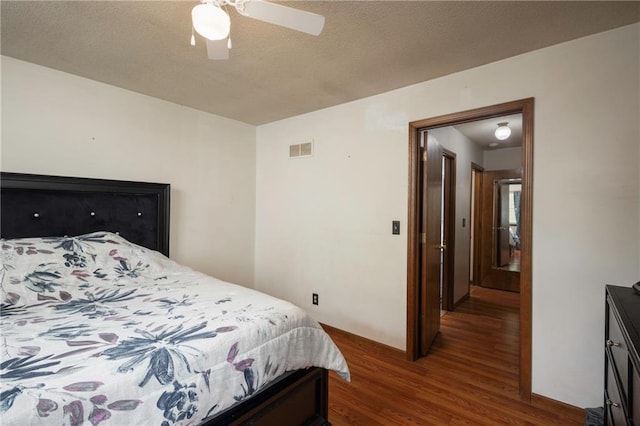 bedroom with visible vents, wood finished floors, a ceiling fan, and a textured ceiling