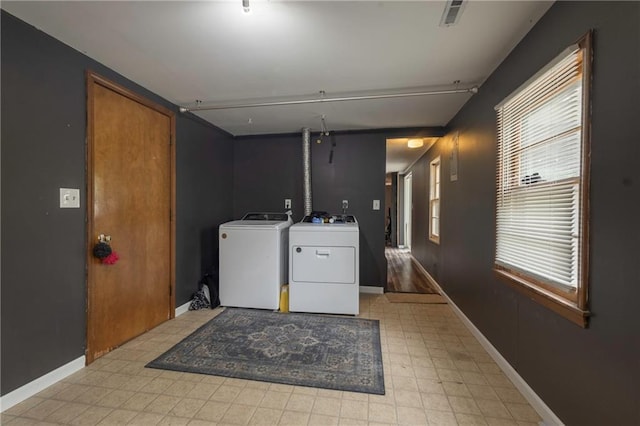 laundry area featuring laundry area, visible vents, baseboards, washer and dryer, and light floors