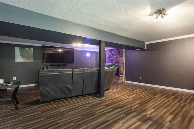 living room featuring a textured ceiling, wood finished floors, and baseboards