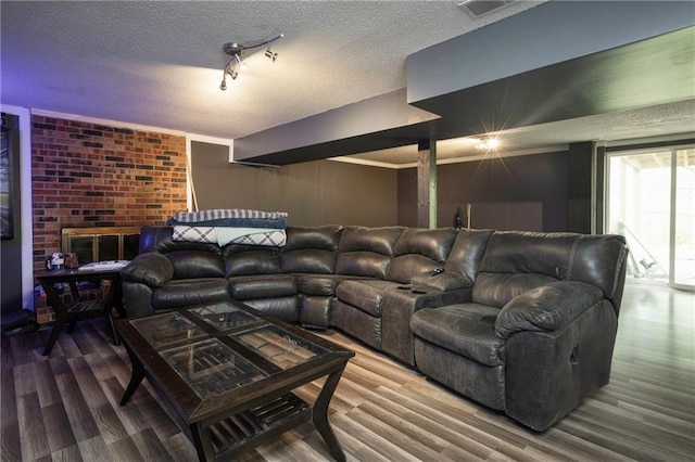 home theater with a textured ceiling, visible vents, and wood finished floors