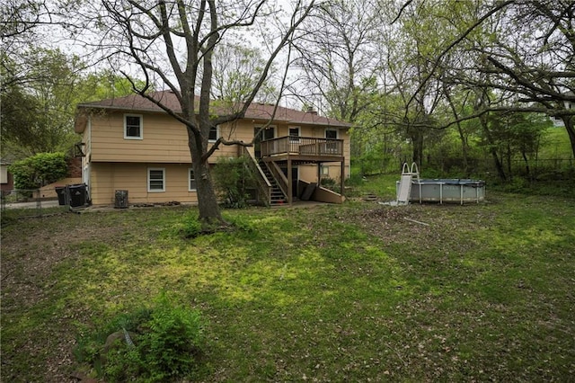 view of yard featuring a deck, stairway, fence, and an outdoor pool