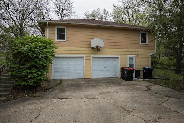 garage with driveway and fence