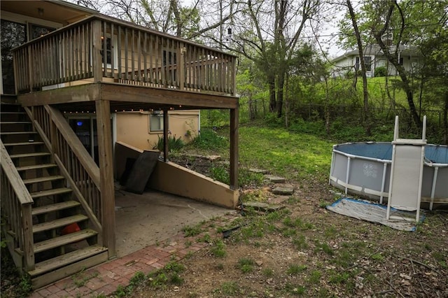 view of yard featuring fence, an outdoor pool, a deck, and stairs