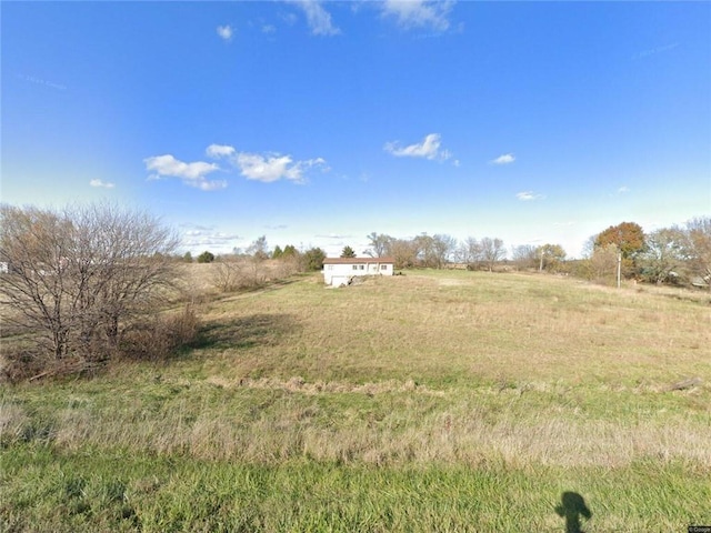 view of green lawn featuring a rural view