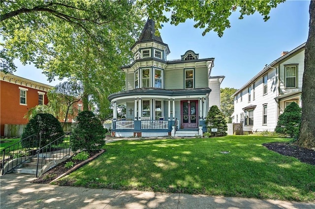 victorian-style house featuring a porch and a front lawn