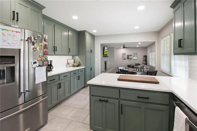 502 Maple Crest Dr, Parsons, KS 67357 - kitchen with stainless steel fridge, green cabinetry, a peninsula, ceiling fan, and recessed lighting