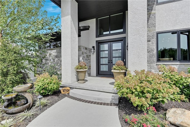 25260 W 104th Pl, Olathe, KS 66061 - view of exterior entry featuring french doors, stone siding, and stucco siding