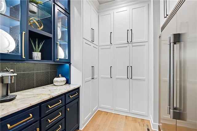 25260 W 104th Pl, Olathe, KS 66061 - kitchen featuring stainless steel built in fridge, blue cabinets, light wood-type flooring, white cabinets, and glass insert cabinets