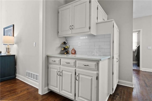 5510 W 153rd Ter, Overland Park, KS 66223 - kitchen with dark wood-style flooring, baseboards, white cabinets, and decorative backsplash