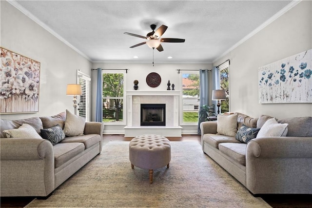 5510 W 153rd Ter, Overland Park, KS 66223 - living area with ceiling fan, wood finished floors, a tiled fireplace, crown molding, and recessed lighting