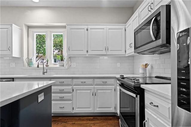 5510 W 153rd Ter, Overland Park, KS 66223 - kitchen featuring appliances with stainless steel finishes, a sink, white cabinetry, decorative backsplash, and recessed lighting