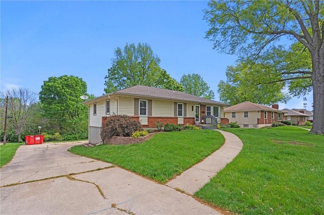 view of front of property with brick siding, driveway, and a front yard