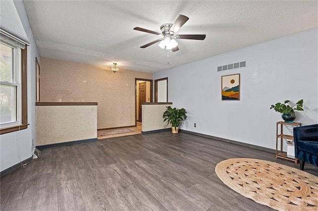 unfurnished room with visible vents, baseboards, ceiling fan, and wood finished floors
