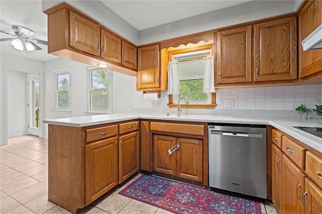 kitchen with a sink, dishwasher, and brown cabinets