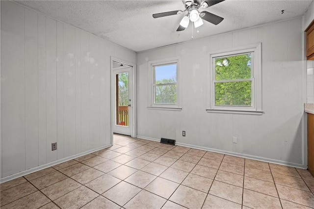 empty room featuring visible vents, baseboards, ceiling fan, a textured ceiling, and light tile patterned floors