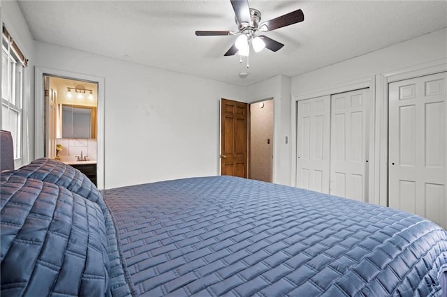 bedroom featuring connected bathroom, ceiling fan, and multiple closets