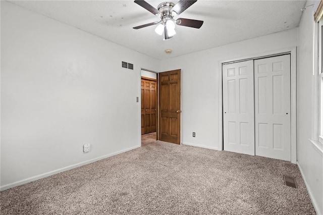 unfurnished bedroom with baseboards, carpet, a closet, and visible vents