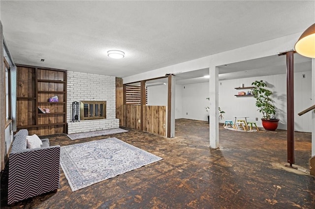 living room with a fireplace, wood walls, and a textured ceiling