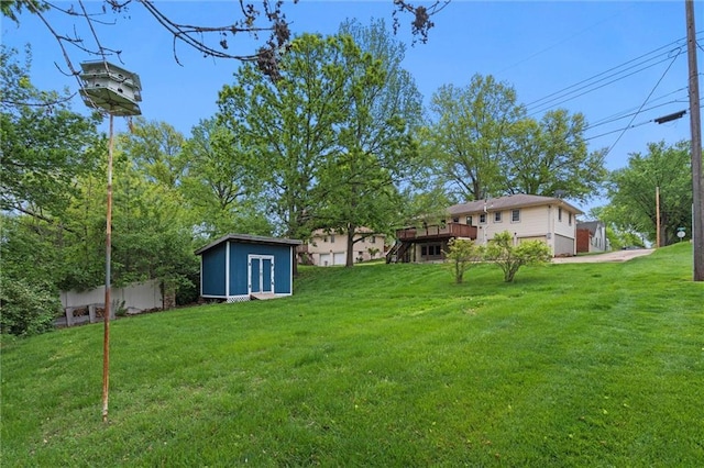 view of yard featuring an outdoor structure, a deck, and a shed
