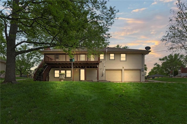 back of property at dusk with stairs, a garage, a yard, and a deck