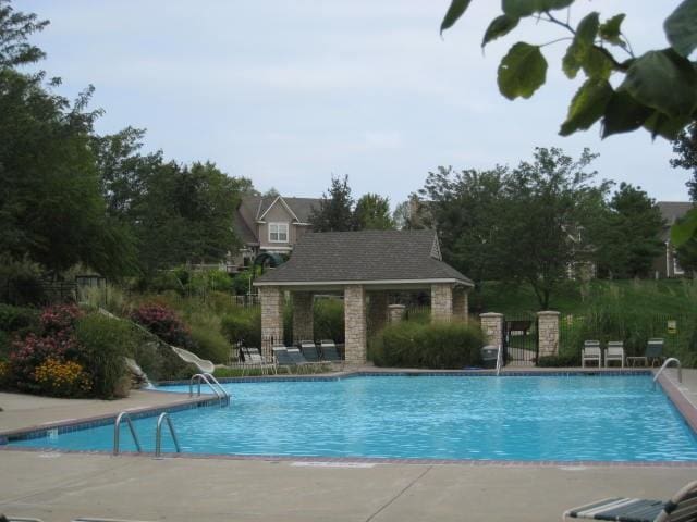 pool with a patio area and fence
