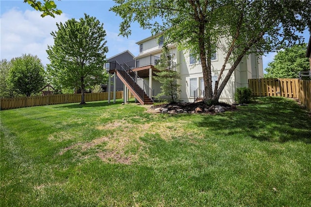 view of yard with a fenced backyard, stairs, and a deck