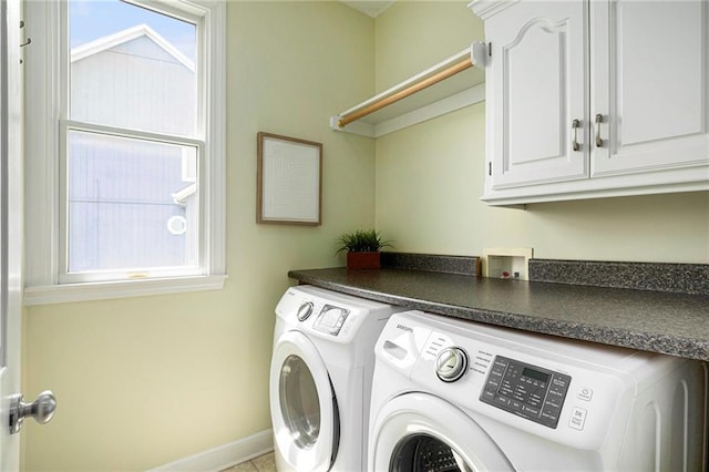 clothes washing area with baseboards, cabinet space, and washer and dryer