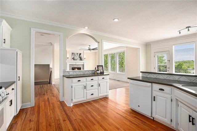 kitchen featuring dark countertops, white appliances, light wood-type flooring, white cabinetry, and a ceiling fan