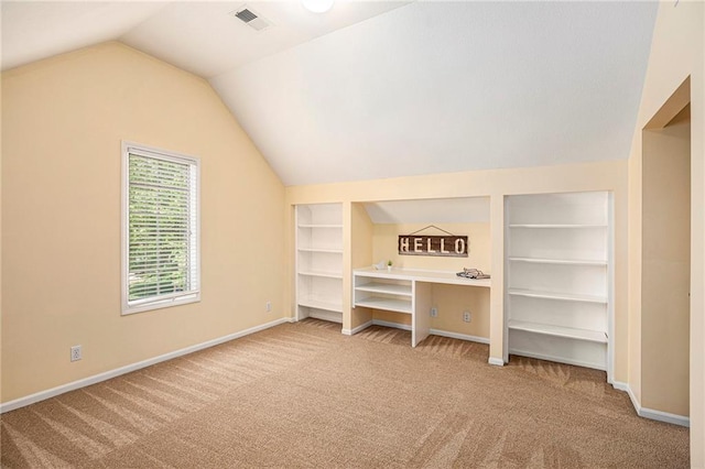 additional living space featuring built in features, carpet, baseboards, lofted ceiling, and visible vents
