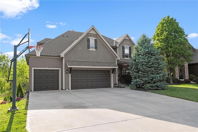 traditional home featuring stucco siding, concrete driveway, a front yard, and an attached garage