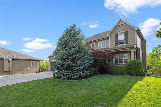 view of front of house featuring a front lawn, stucco siding, and driveway