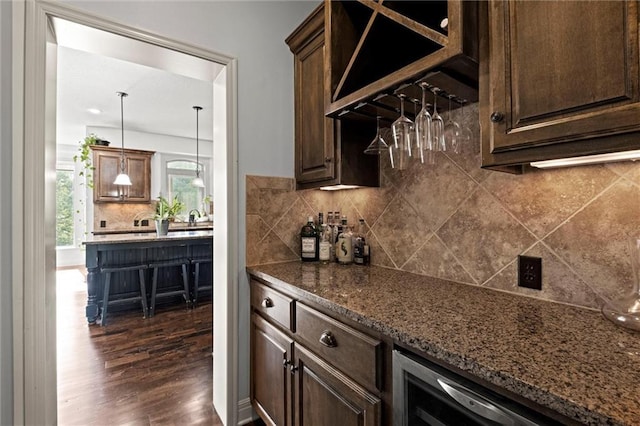 indoor dry bar featuring dark wood-type flooring, tasteful backsplash, and wine cooler