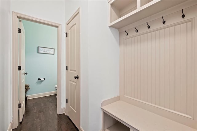 mudroom featuring dark wood-type flooring and baseboards