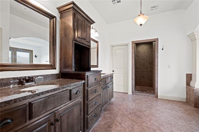 full bath featuring tiled shower, tile patterned floors, and vanity