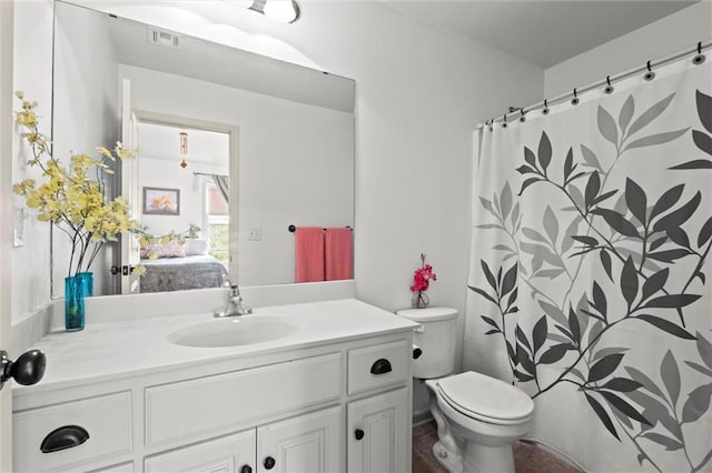 ensuite bathroom featuring vanity and toilet