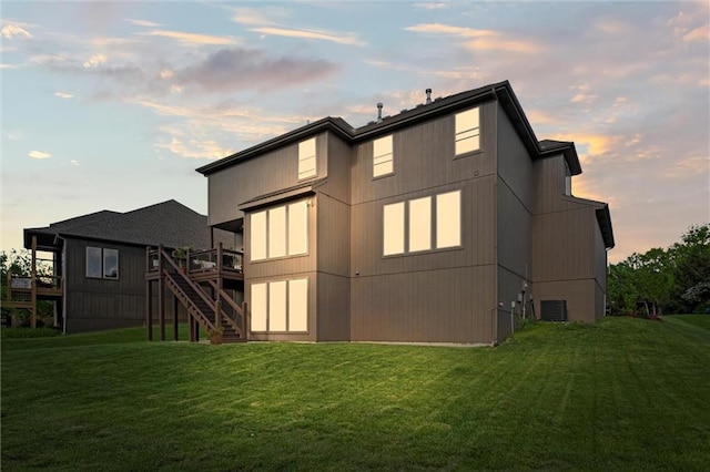 back of property featuring a lawn, stairway, a deck, and central AC unit