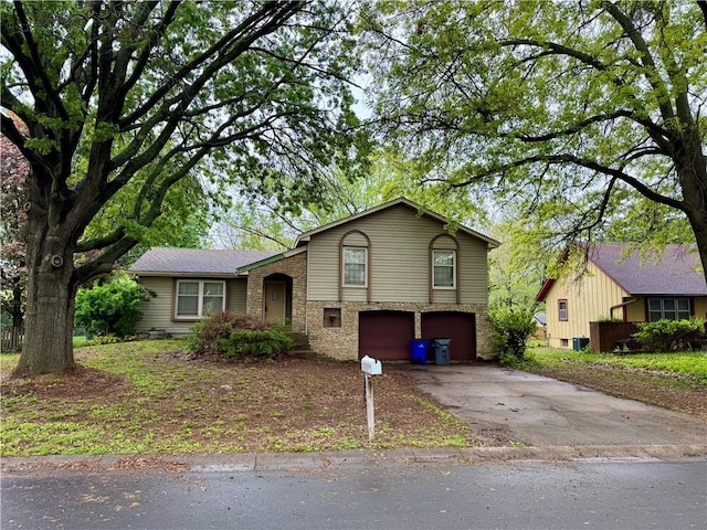 split level home with aphalt driveway and an attached garage