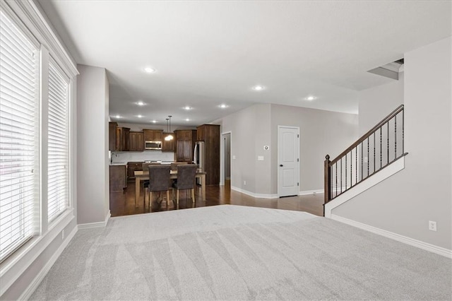 living room featuring carpet floors, recessed lighting, baseboards, and plenty of natural light