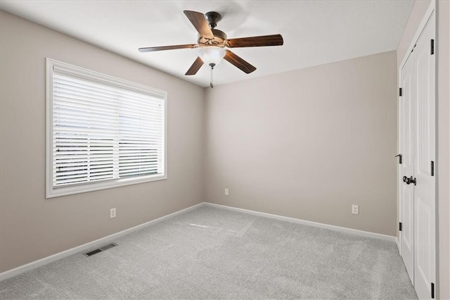 carpeted spare room with baseboards and ceiling fan
