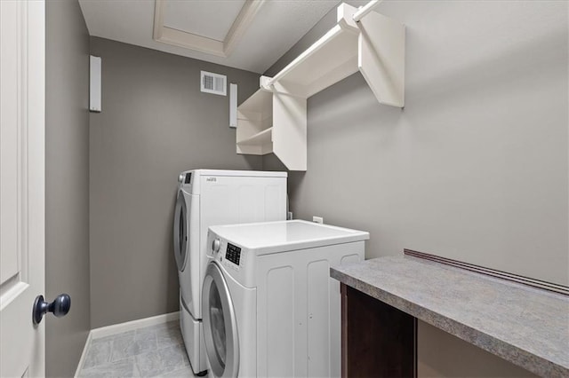 laundry area with washing machine and clothes dryer and baseboards