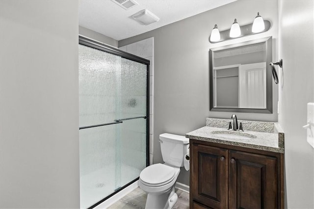 full bathroom with a shower stall, toilet, vanity, and wood finished floors