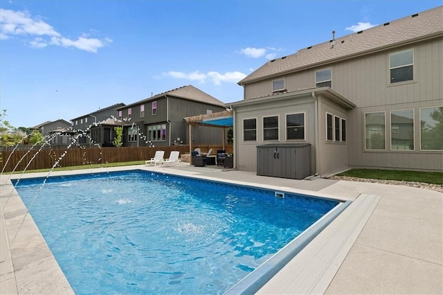 view of swimming pool with fence, a patio area, and a residential view